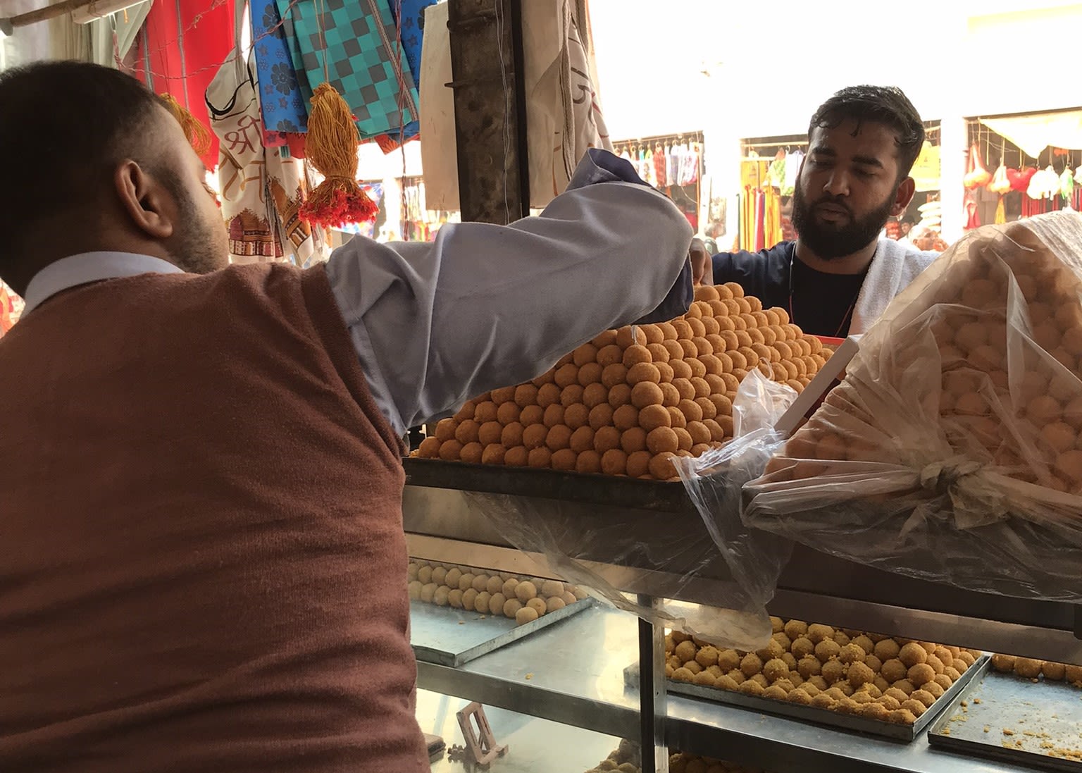 Sunil Gupta owns a laddoo shop in close proximity to the Hanuman Garhi temple. He suffered a significant loss of land during the acquisition process, and although the laddoos may receive a GI tag, the future of his business hangs in the balance if the rest of the shop is also acquired. Credit: DH Photo/Anand Singh